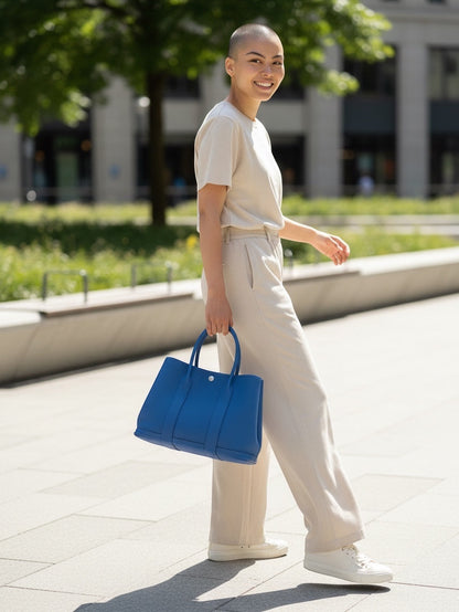 Bagsational Hermes Neogonda Garden Party 30 tote bag in vibrant blue leather held by a woman in a neutral outfit