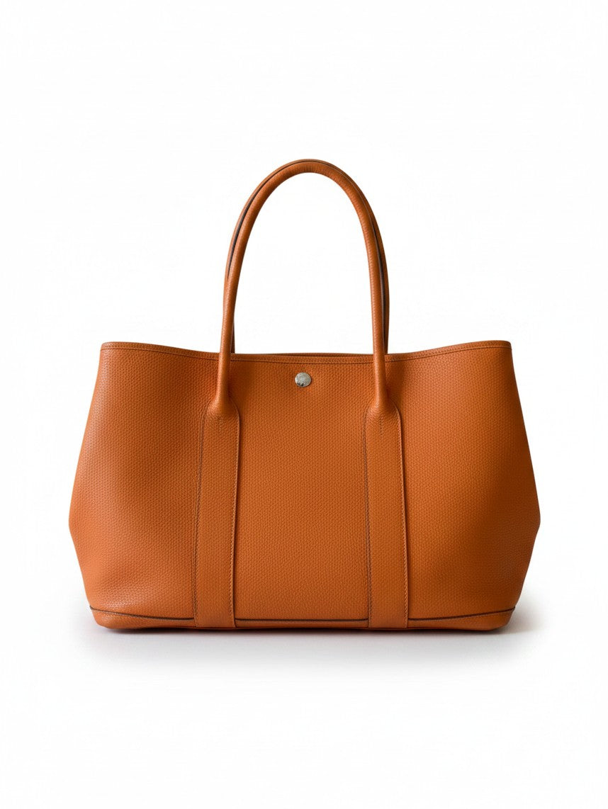 Bagsational Hermes Garden Party 36 tote in fiery orange Feu Negonda leather with a minimalist snap closure design.