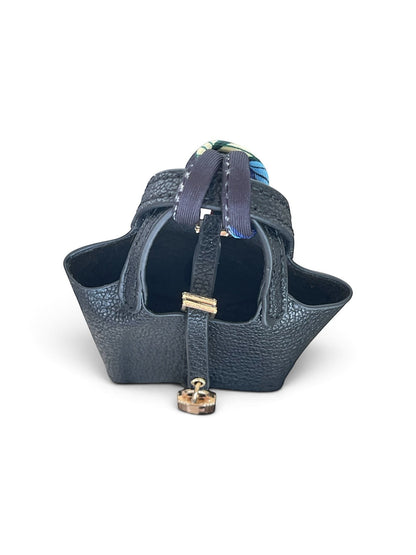 Bagsational mini black pebbled leather bucket bag charm with a decorative patterned handle strap